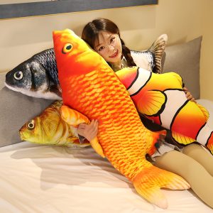 A pile of giant realistic fish pillows on a bed