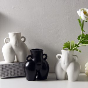 Ceramic vase shaped like a bottom holding tulips