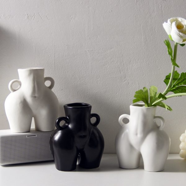 Ceramic vase shaped like a bottom holding tulips
