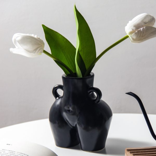 Ceramic vase shaped like a bottom holding tulips