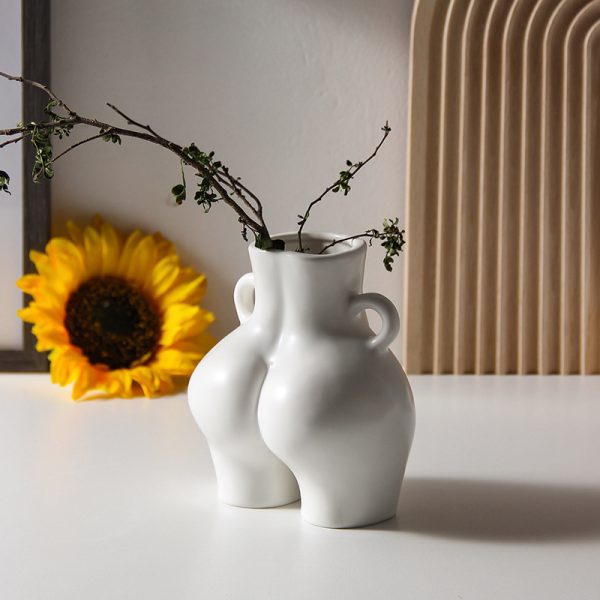Ceramic vase shaped like a bottom holding tulips