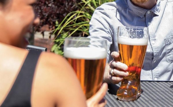 Friends drinking from beer boot glasses