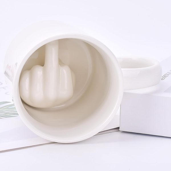 White mug with a sculpted middle finger inside