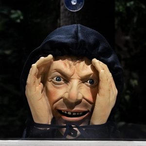 Scary peeper prop of a hooded man pressing his face to a window
